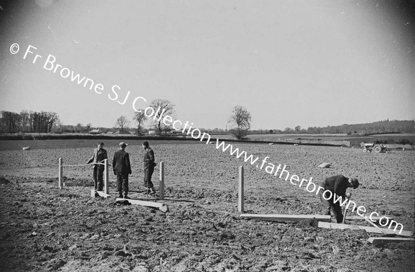 PUTTING UP NEW FENCE POSTS IN NEWLY CLEARED FIELD